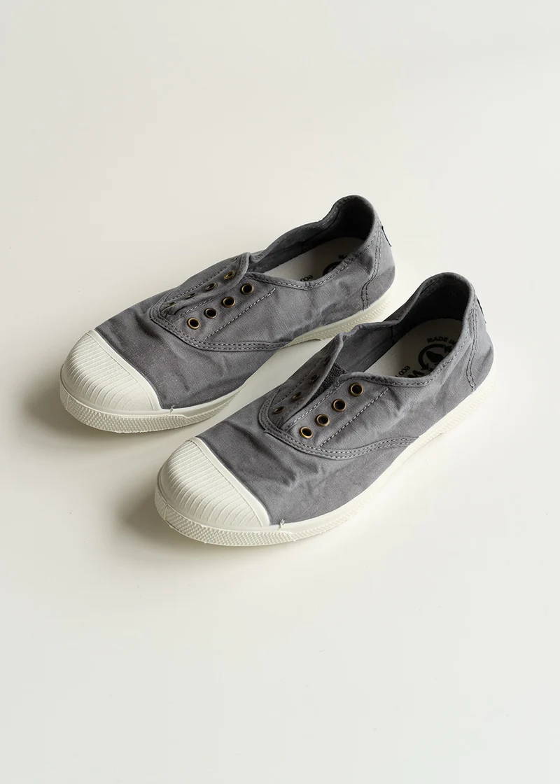A pair of grey canvas pumps with a white rubber sole.