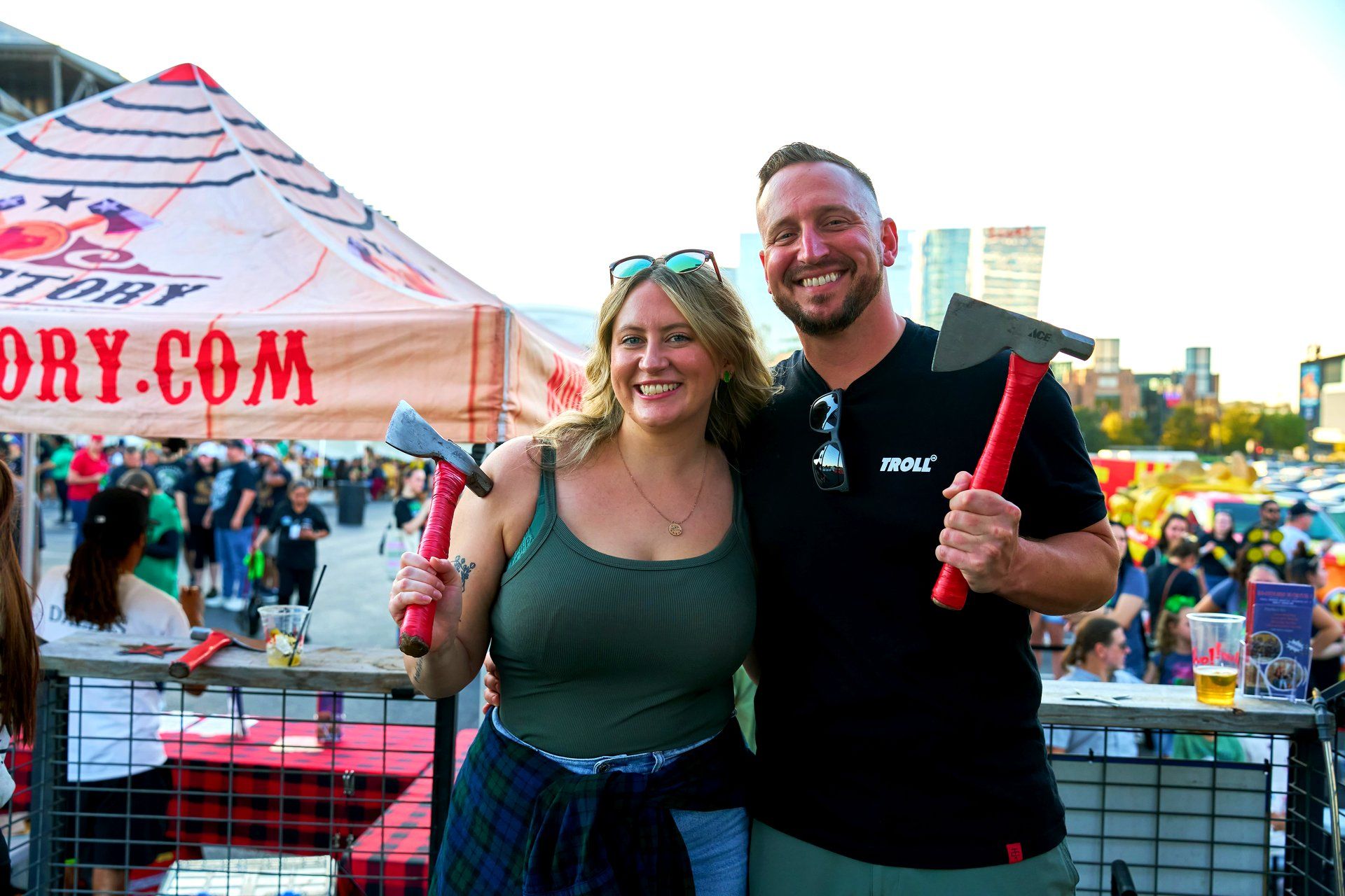 Two guests pose with axes at the free axe throwing activation at The Big Dill pickle festival, Globe Life Field and Texas Live!, Arlington Texas 2025.