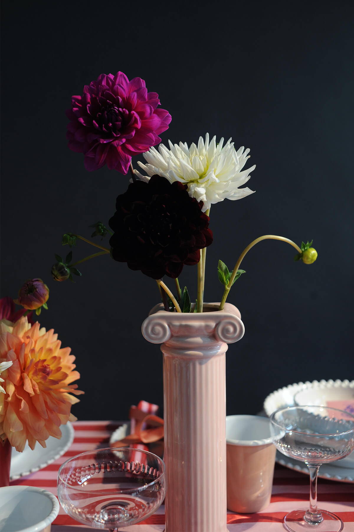 A close up of the Doiy Athena Vase in Pink, with 3 dahlia stems inside.