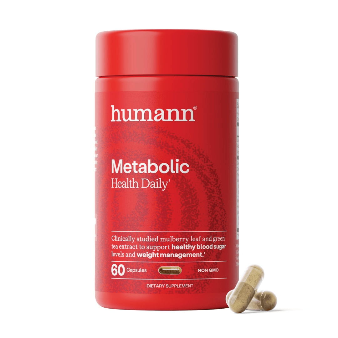 Humann Metabolic Health Daily supplement bottle with two capsules beside it.