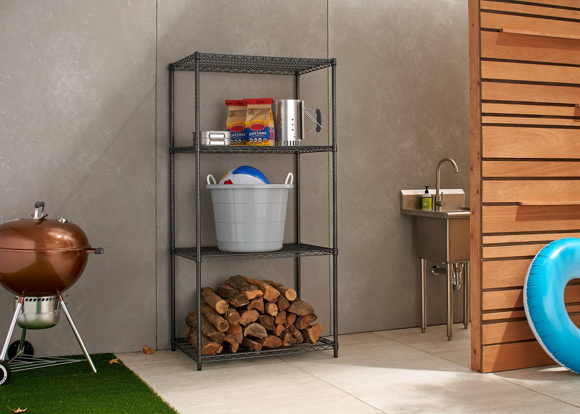 Outdoor wire shelving rack filled with fire wood and other patio kitchen supplies