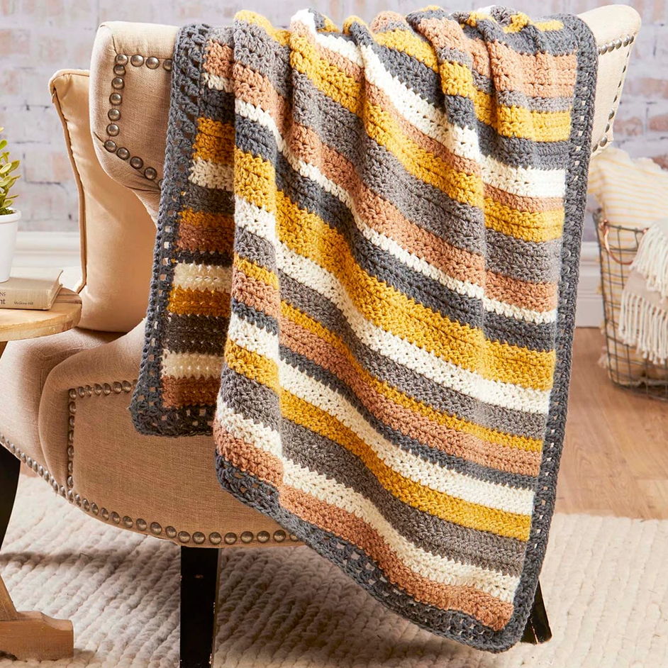 A cozy striped blanket draped over a chair.