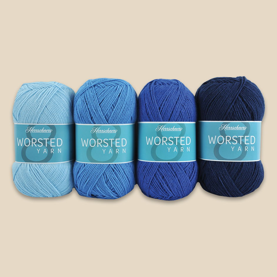 Four skeins of Herrschners Worsted Yarn in various shades of blue.