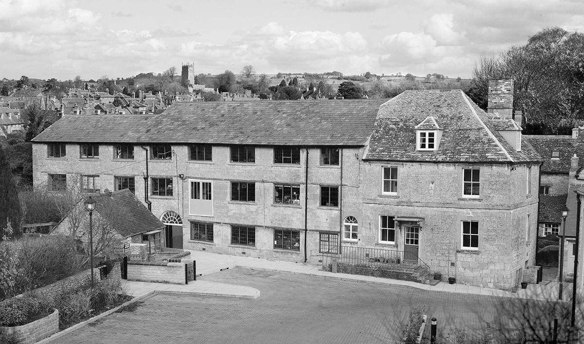 Historic stone buildings in a rural setting, captured in black and white.