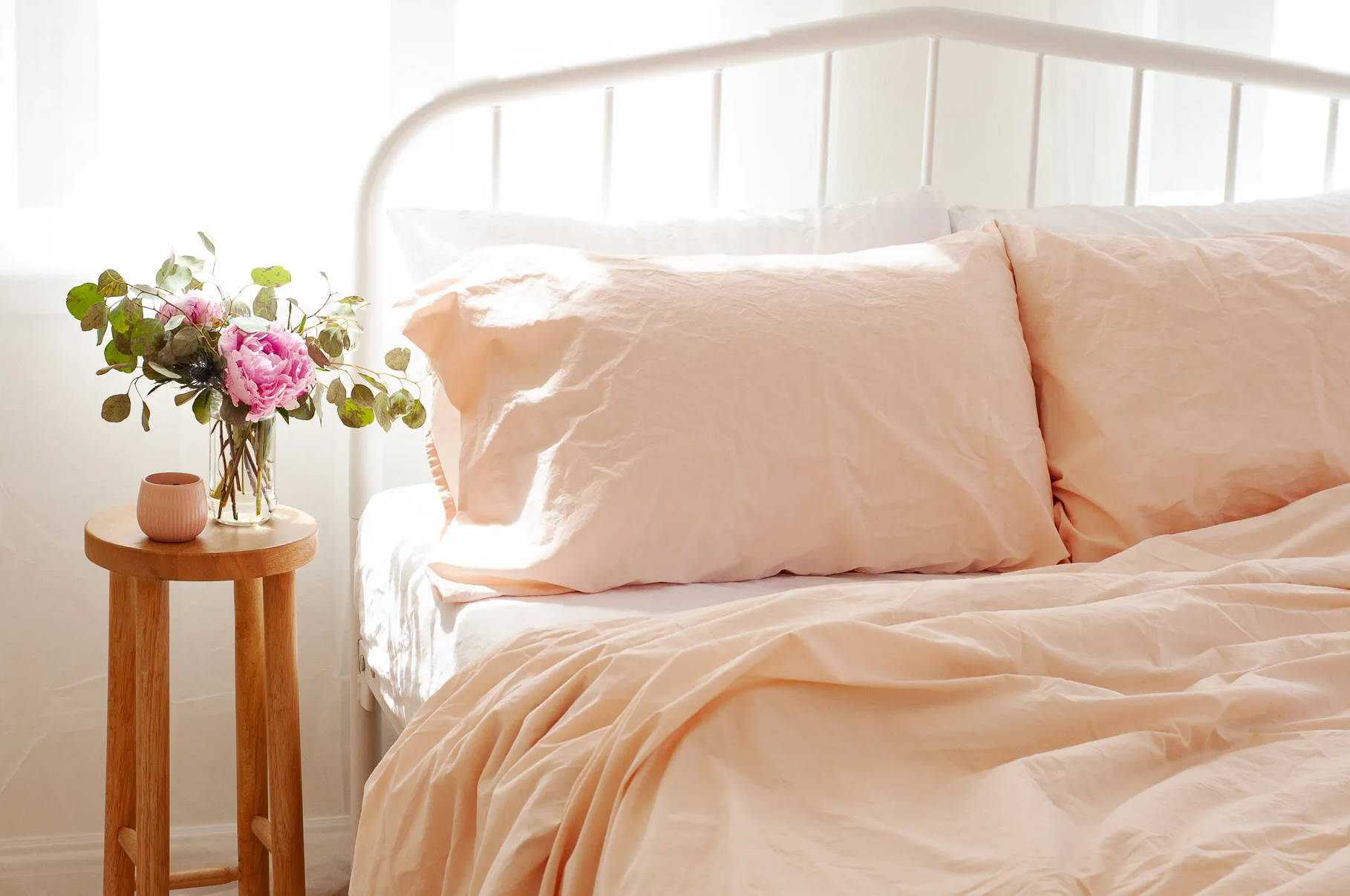 an airy bedroom scene displays a combination of the white and peach cinkle percale cotton sheet sets 