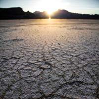 Parched, cracked soil in a desert with mountains in the background