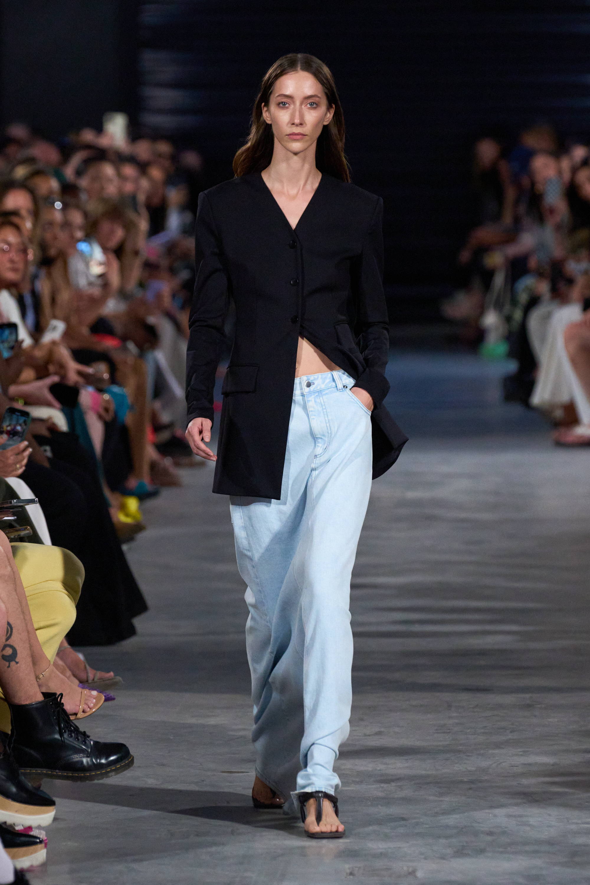Model on a runway wearing a blazer and skirt