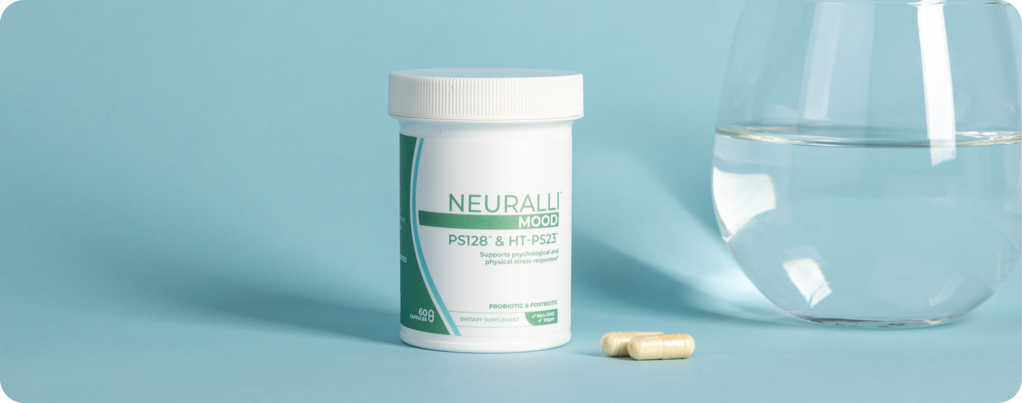 Container of Neurogan supplements beside a glass of water.