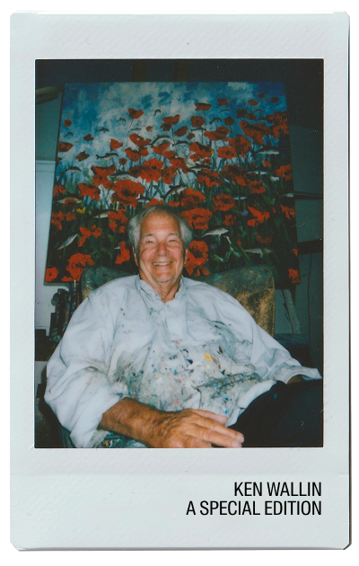 Elderly man smiling in front of a colorful floral painting.