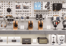 Headphones and audio accessories displayed on a wall shelf.
