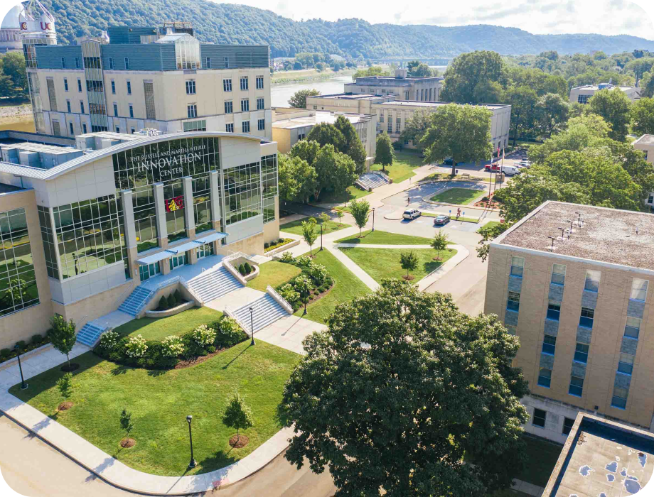 Aerial view of a campus with buildings and green spaces.