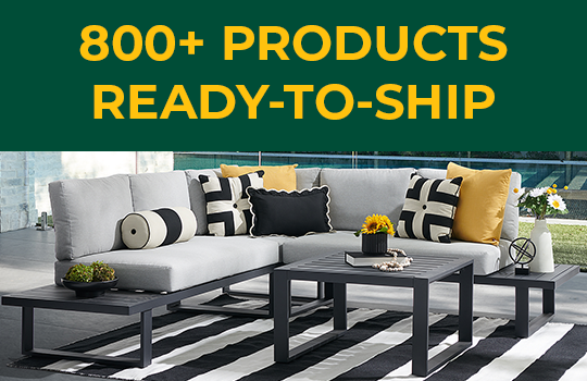A modern outdoor seating area with decorative pillows and a coffee table.
