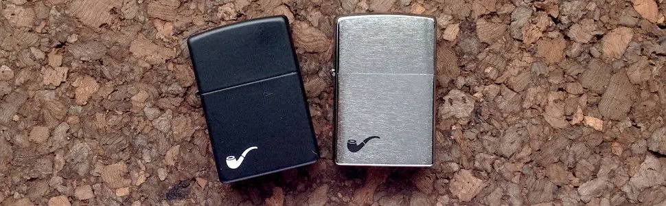 Black Matte and Chrome Pipe lighters, laying flat on cork board