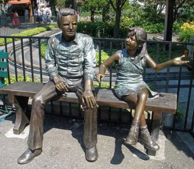 Grandpa & granddaughter sitting on a park bench statue