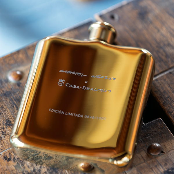 Gold flask on a wooden surface with limited edition branding.