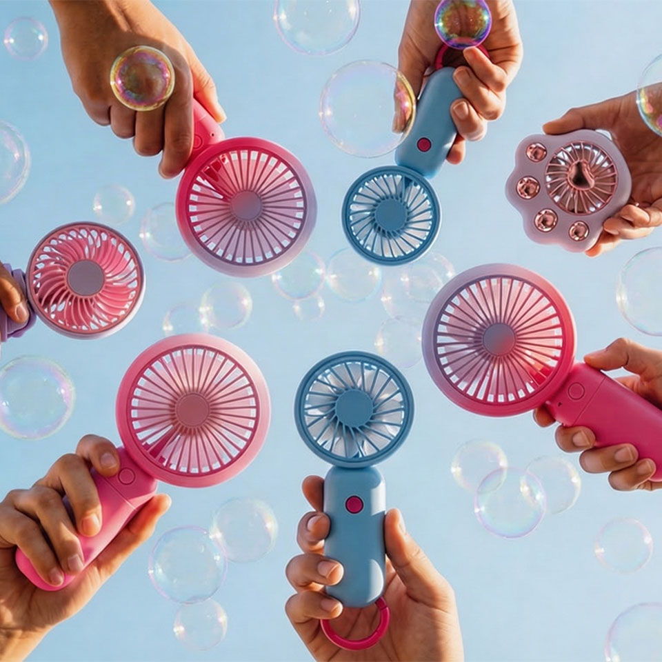Hands holding colorful fans with bubbles against a blue sky.