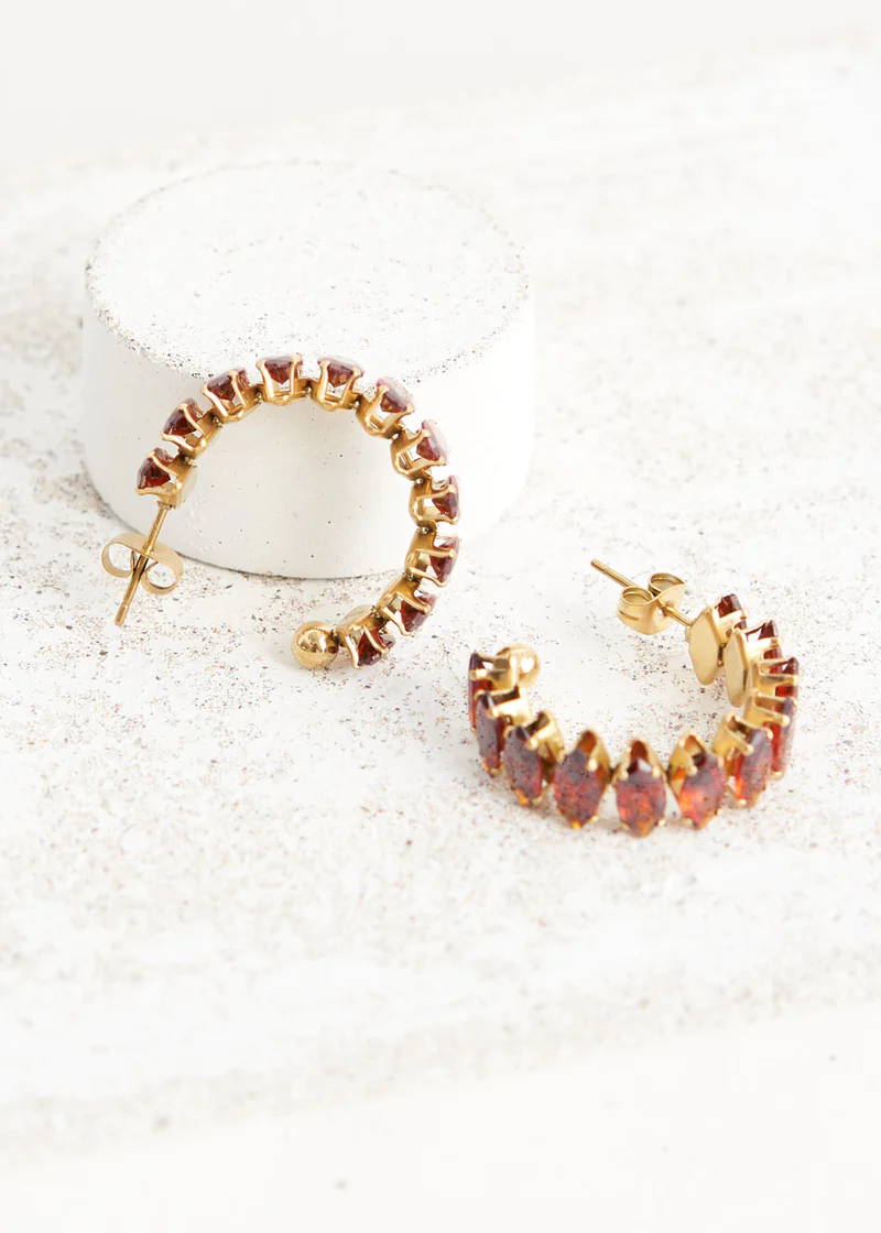 A pair of oversized chunky half hoop earrings with amber coloured crystals