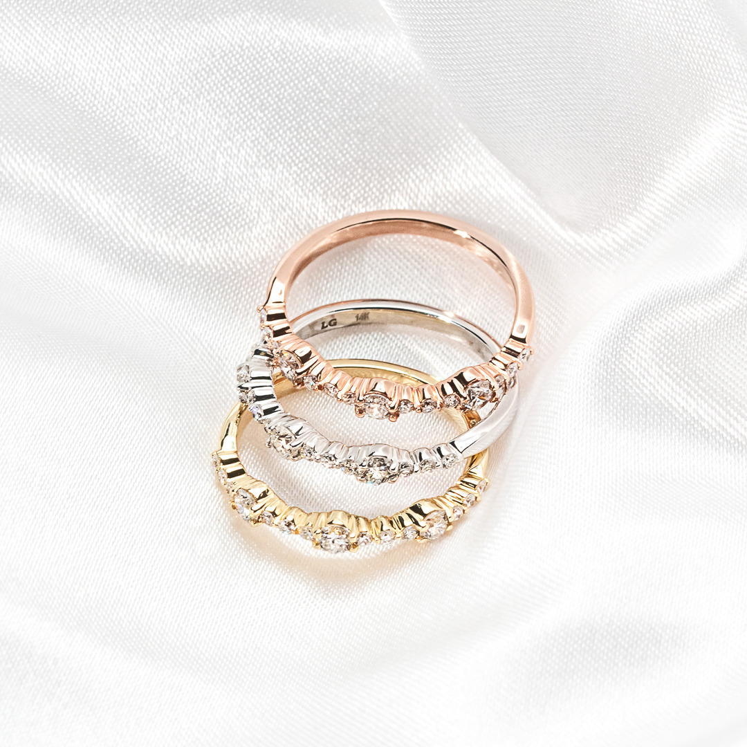 multi stone diamond accented stackable gold rings shown in yellow, white and rose gold