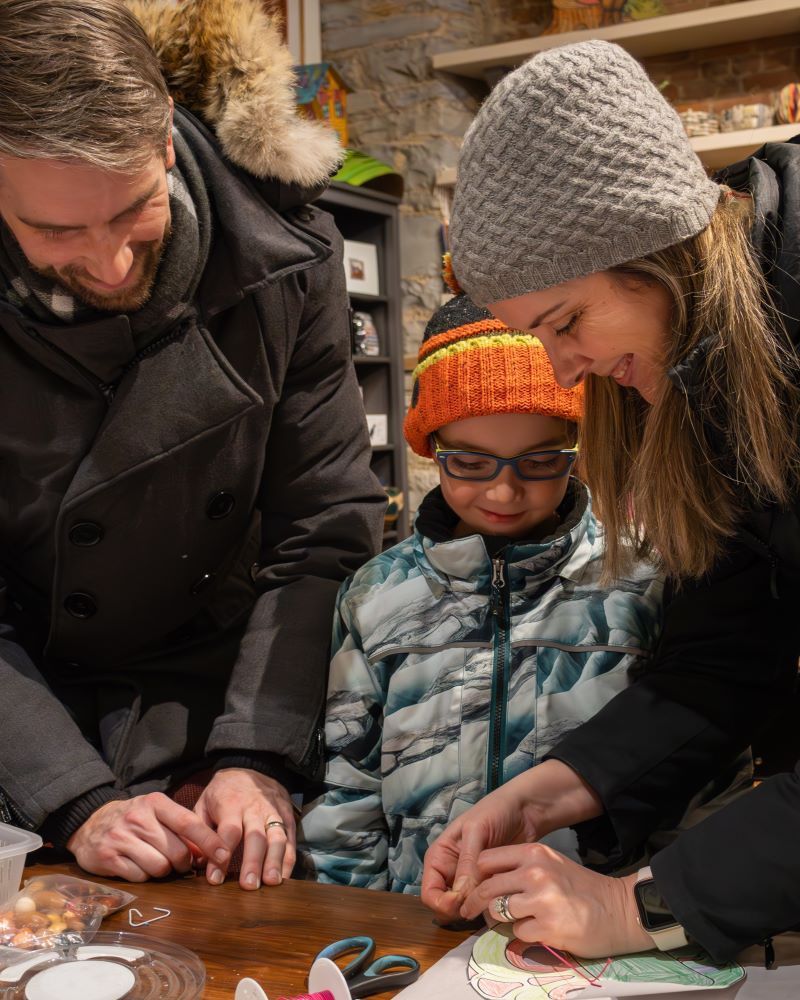 A family engages in a creative activity at a table.