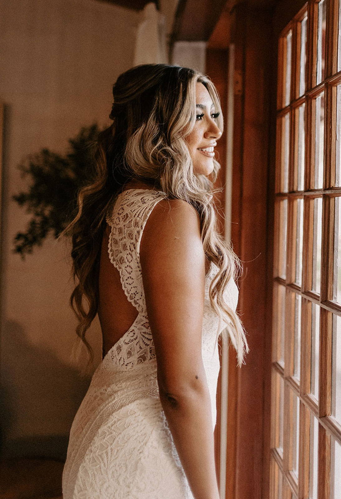 Bride wearing the Chelo gown looking out window