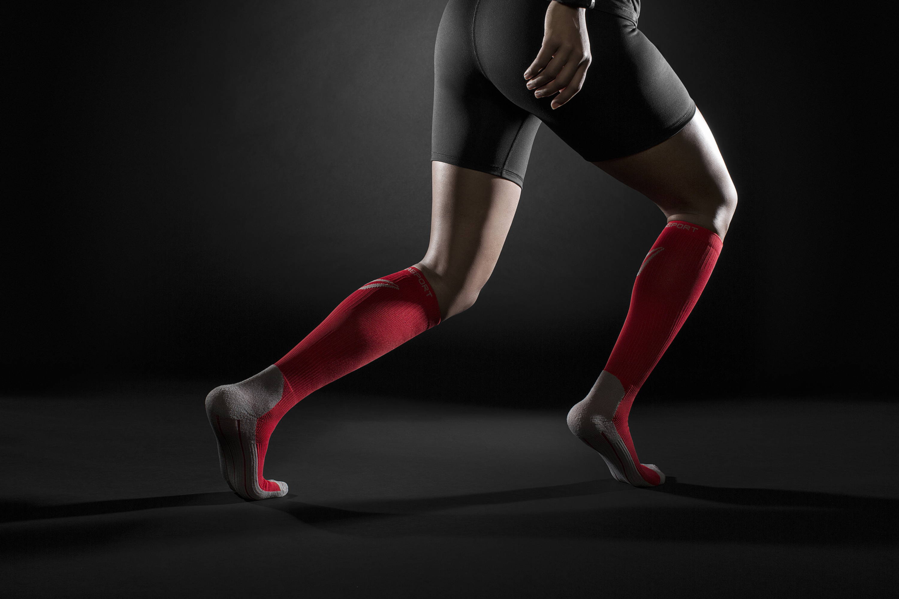 Woman running with red Therasport compression socks