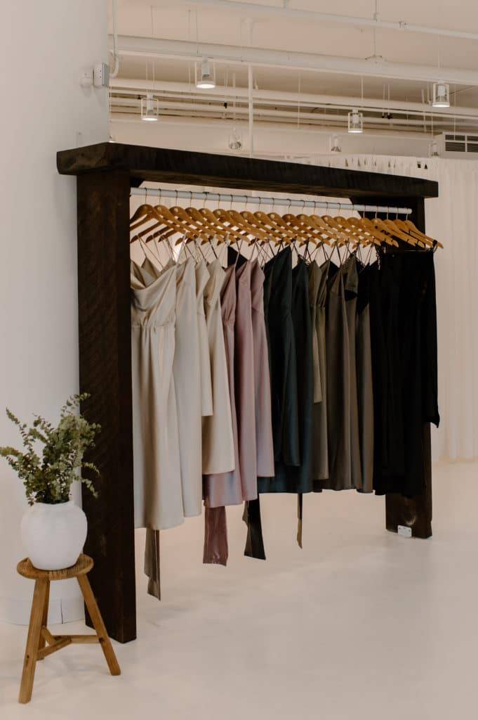 Grace Loves Lace silk bridesmaids slip dresses hanging on a thick dark timber rack