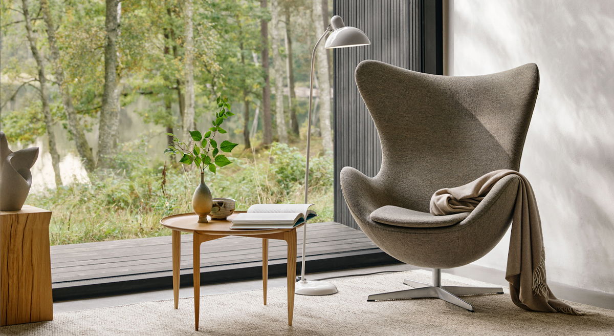 Cozy living space with a stylish Egg Lounge Chair by Arne Jacobsen for Fritz Hansenand wooden table.