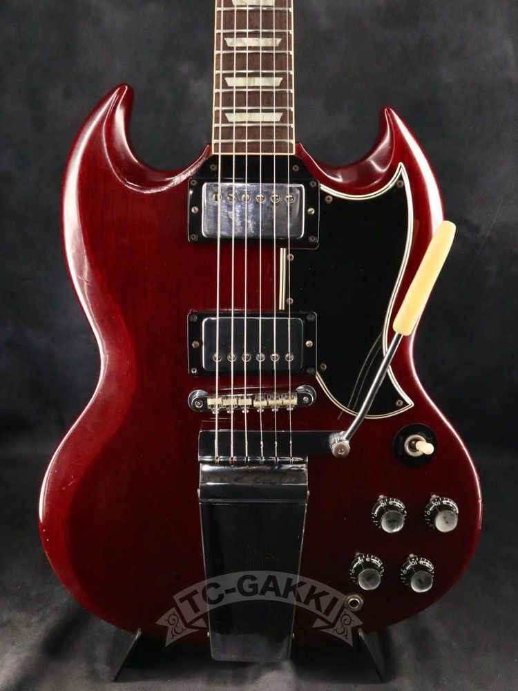 Red electric guitar with dual pickups and control knobs.