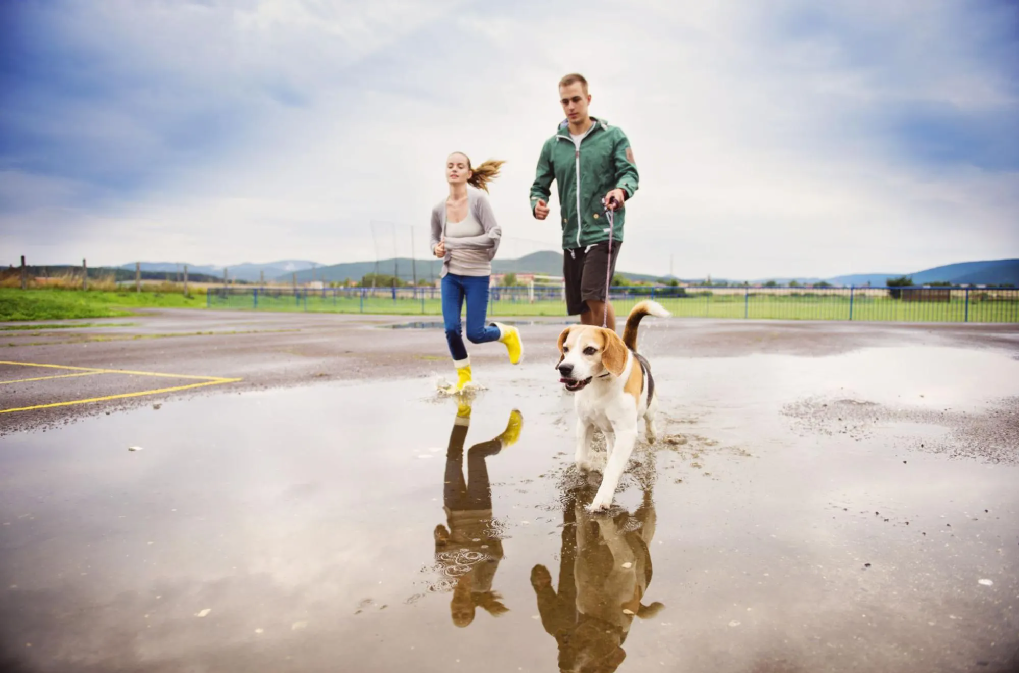 couple running outdoors with dog