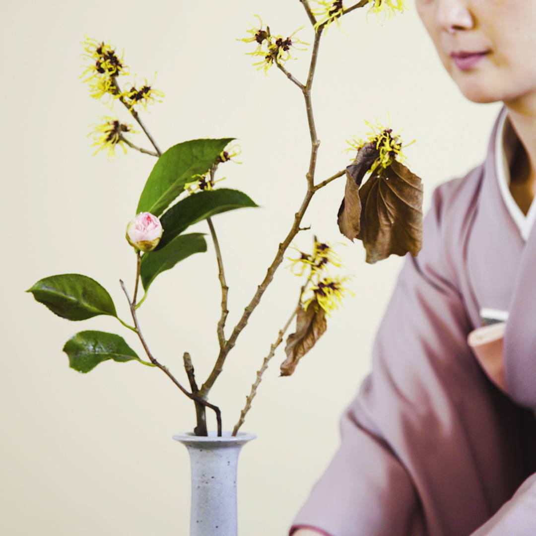 woman with floral arrangement - organic loose leaf green tea 