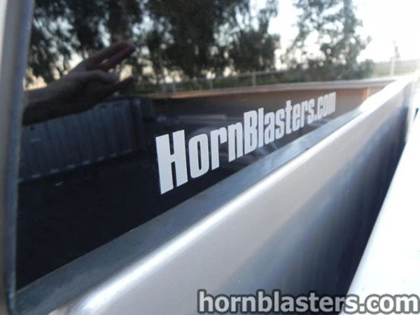 Close-up of the HornBlasters.com decal on the rear window of Thomas's silver 2005 Chevrolet Silverado 1500, install photo 13