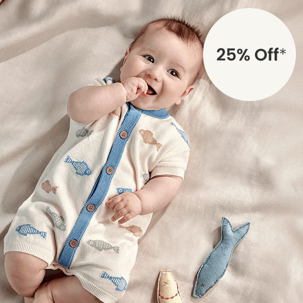 Baby in a whale-patterned romper with a discount tag nearby.