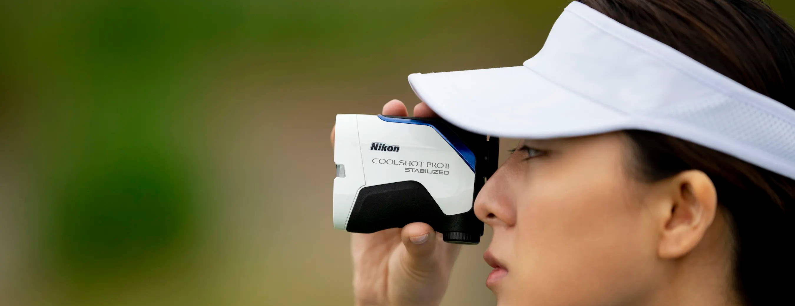 Woman golfer looking through the Nikon COOLSHOT PROII STABILIZED