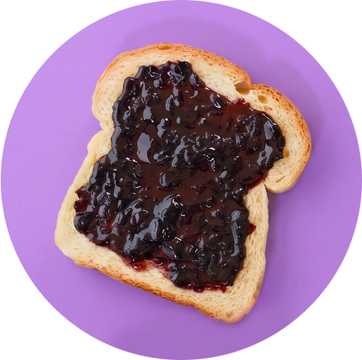 Slice of toasted bread topped with Tastefully Simple Blissful Blueberry Jam on a purple background.