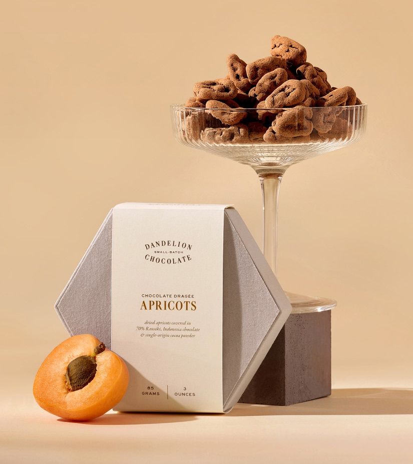 A box of dried apricots with a glass of apricot snacks.