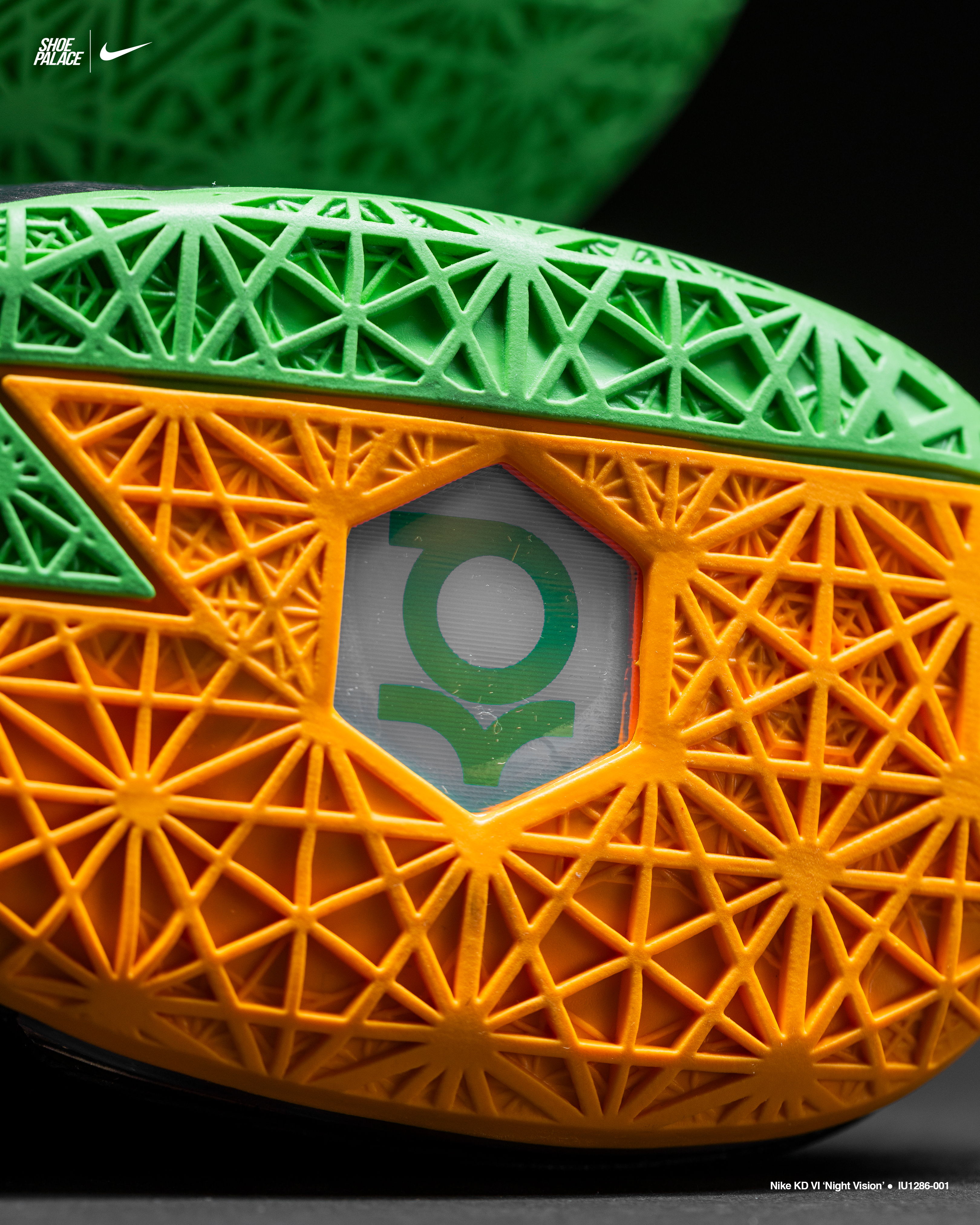 Close-up of a textured shoe sole with orange and green design elements.