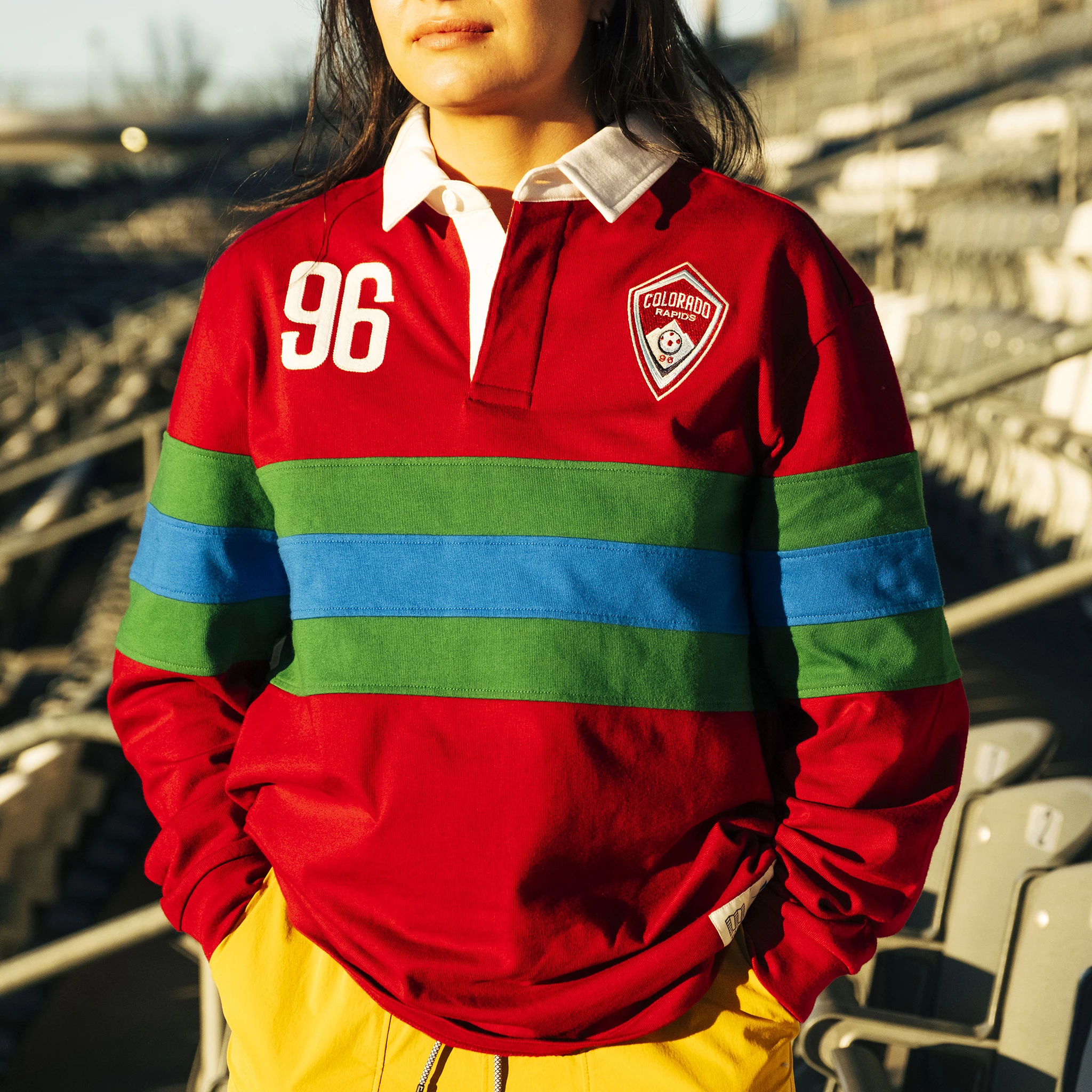 Person wearing a colorful rugby shirt standing in a stadium.