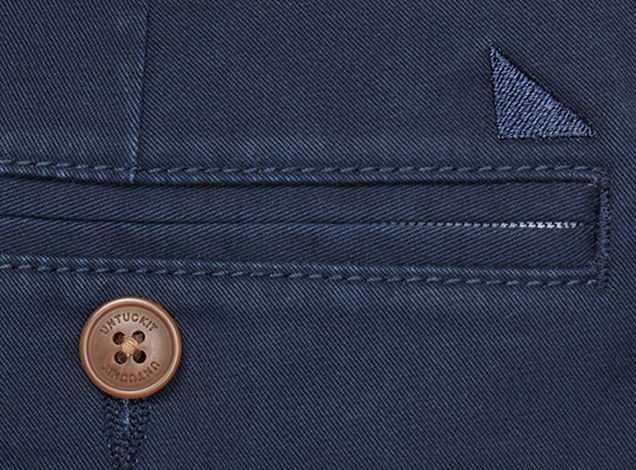 Close-up of a navy fabric with a button and pocket detail.