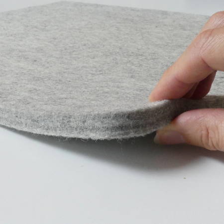 hand showing the thickness of a wool pressing mat