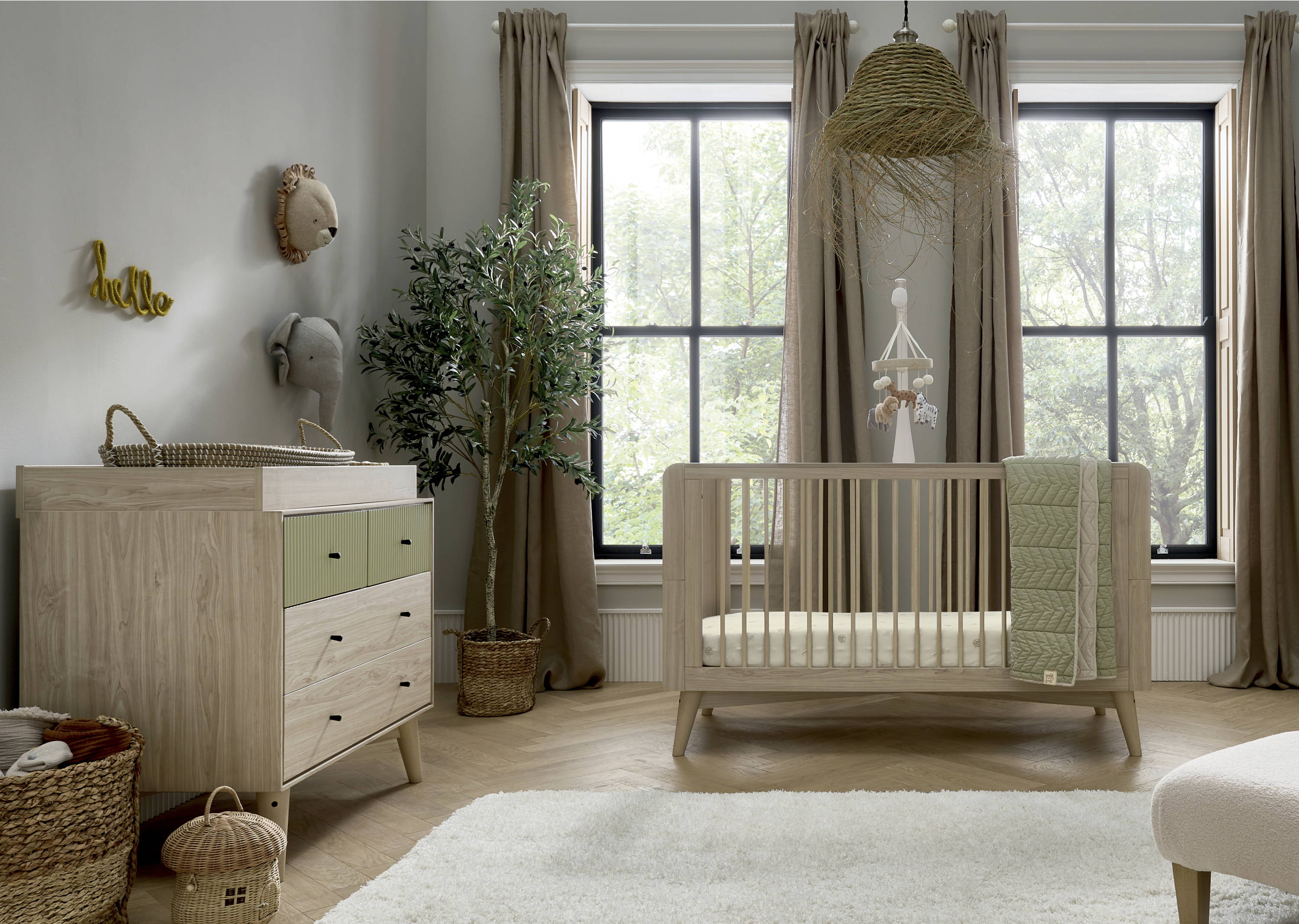 The Mamas and Papas Coxley cotbed and dresser changer stand in a modern nursery with large windows.