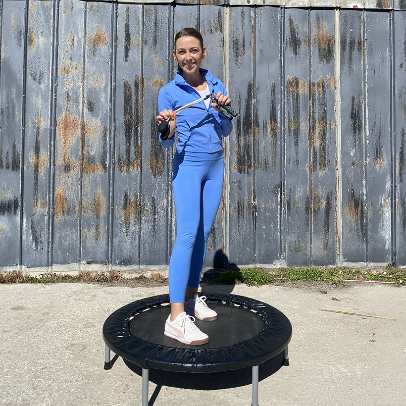 Woman standing on a rebounder with Crossrope Ropeless jump ropes