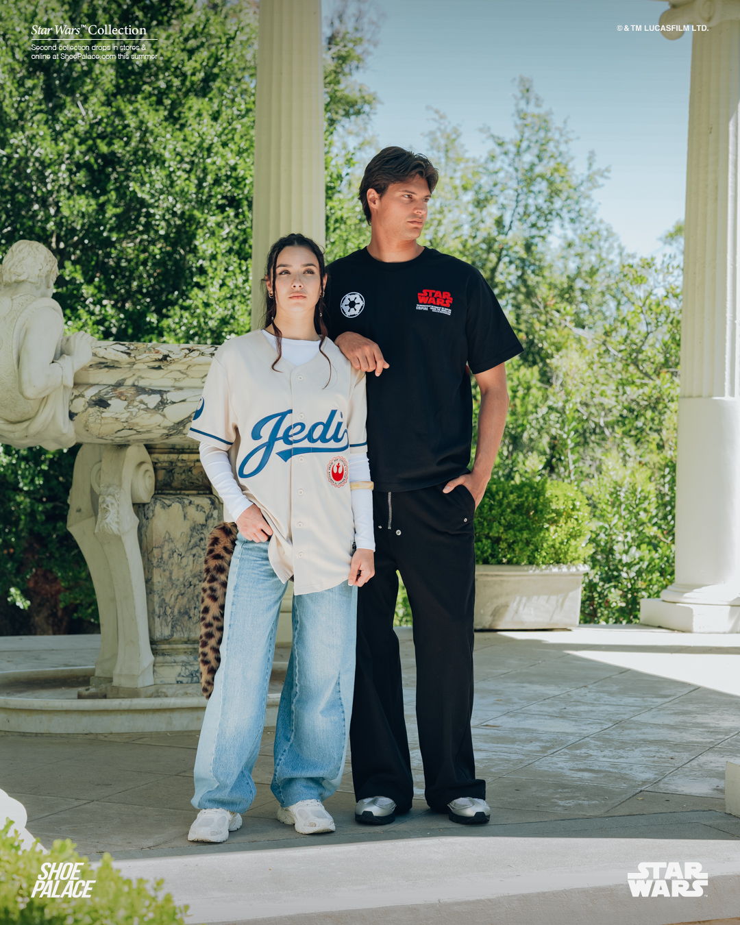 Two people in casual clothing standing outdoors near a statue.