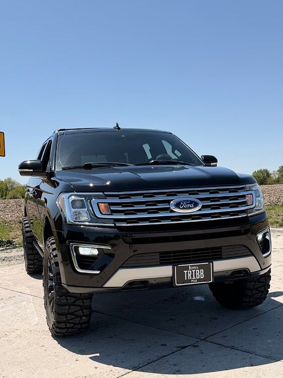 Front-three-quarter view Troy's black 2018 Ford Expedition with TRIBB Iowa license plate and off-road tires under clear blue sky gallery photo 6