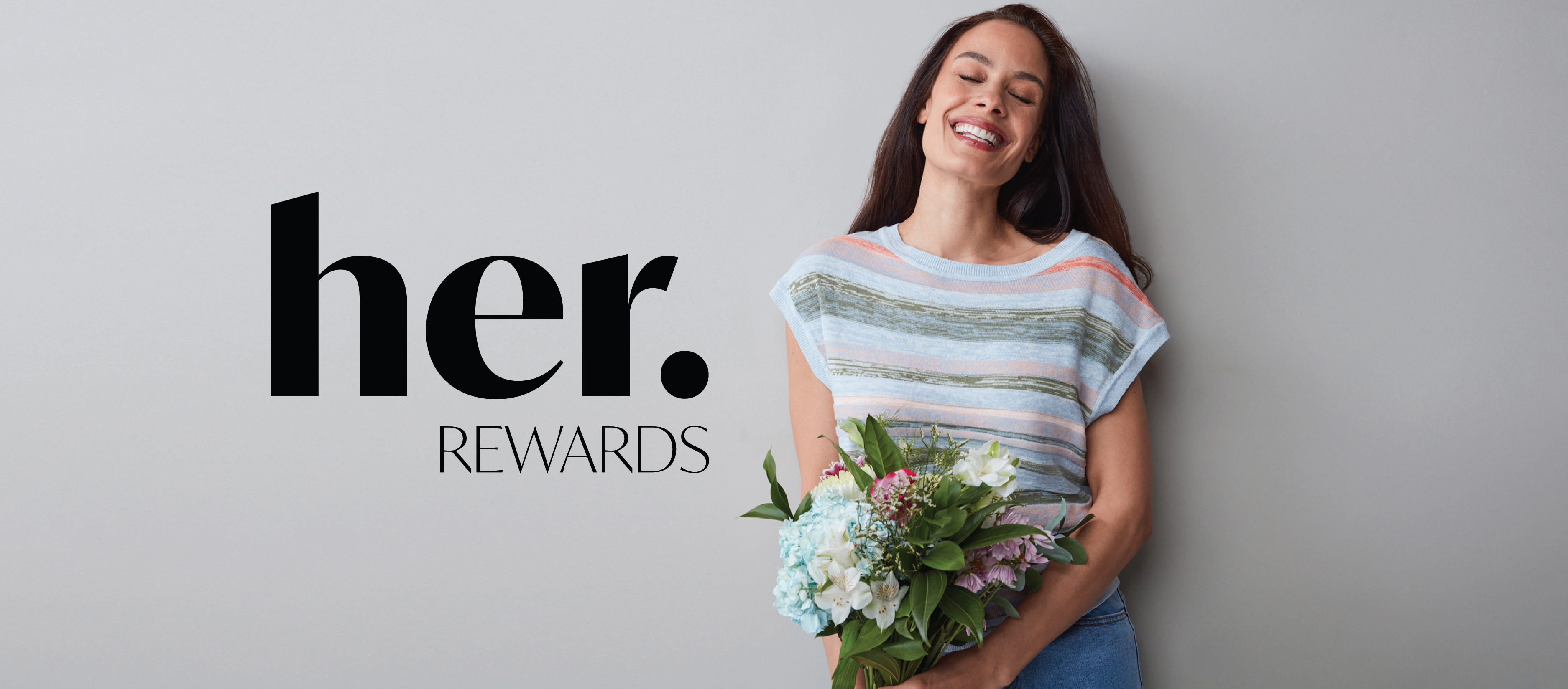 Smiling woman holding flowers next to 