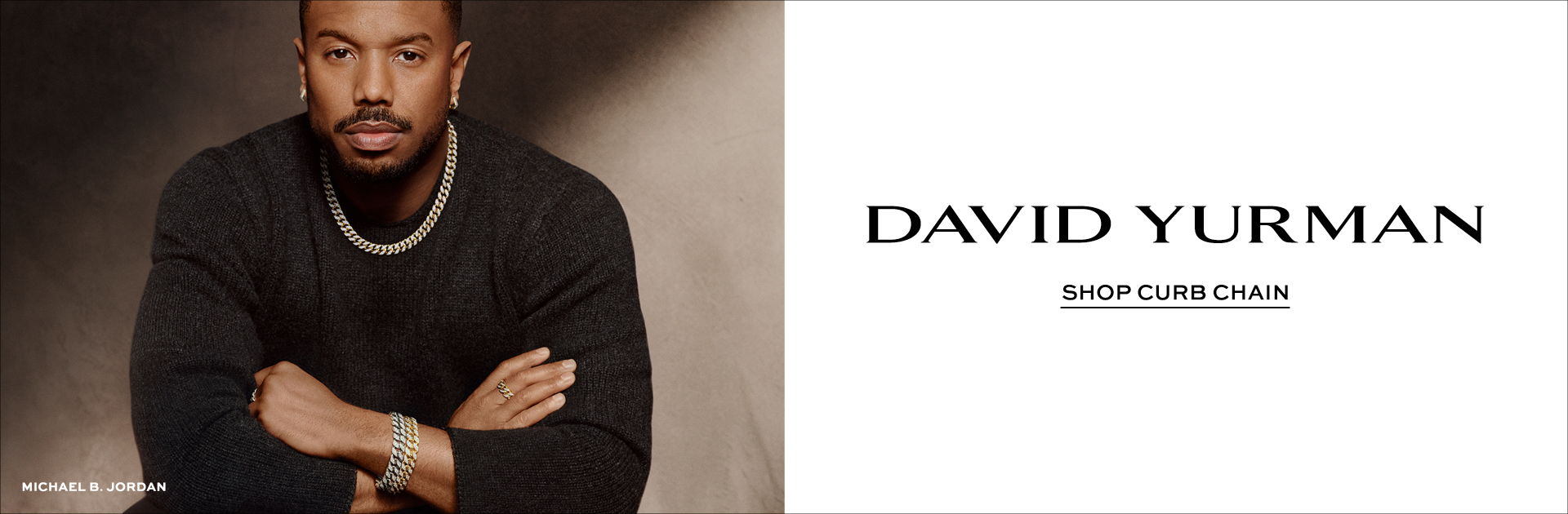 A man in a black shirt poses alongside the David Yurman logo.