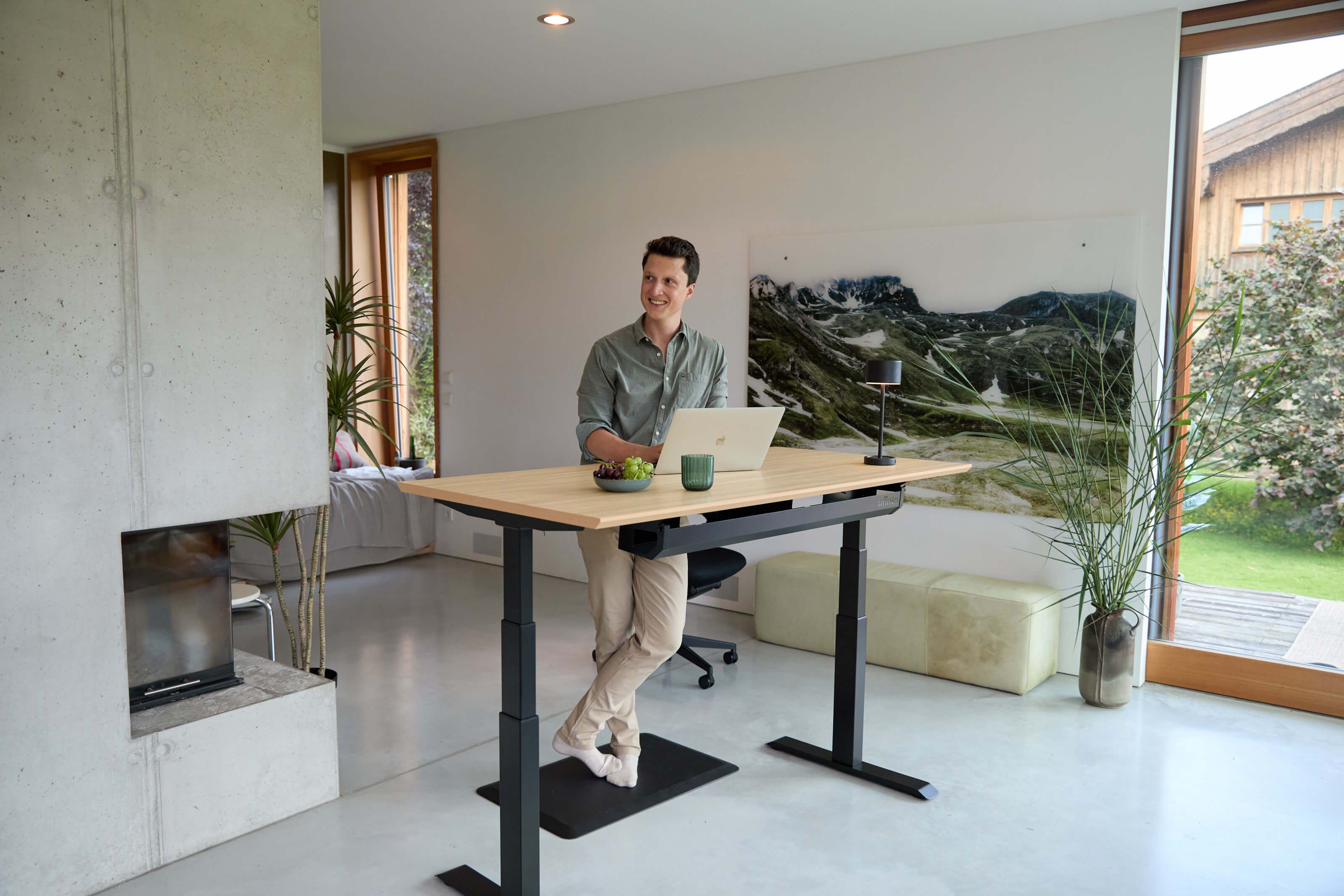A man stands at an Elevate height-adjustable office desk Elevate his home office