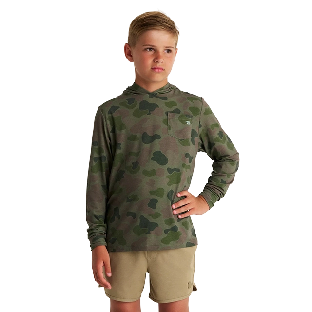 Boy in camo long-sleeve shirt and shorts, posing confidently.