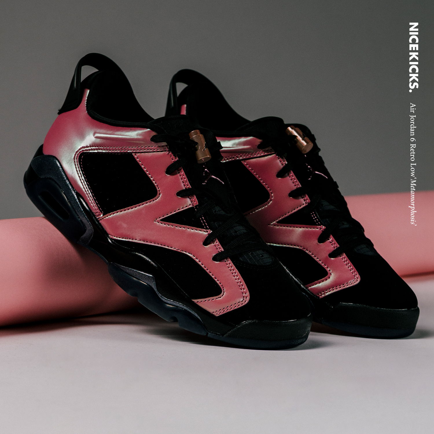 Black and pink athletic shoes on a neutral background.