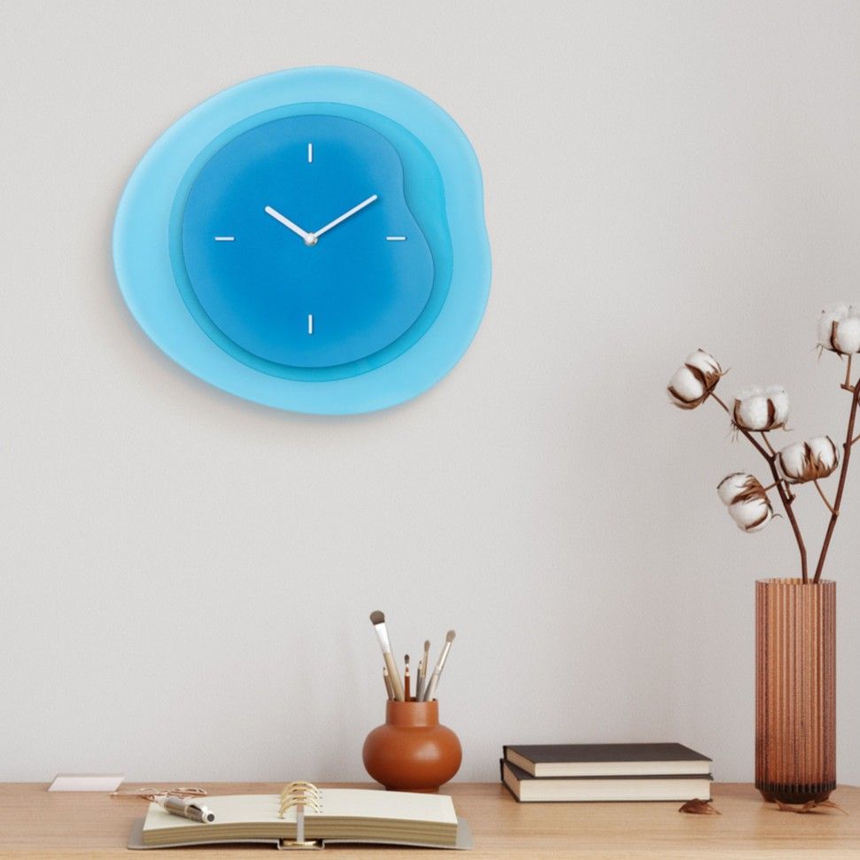 A blue wall clock above a wooden table with decorative items.