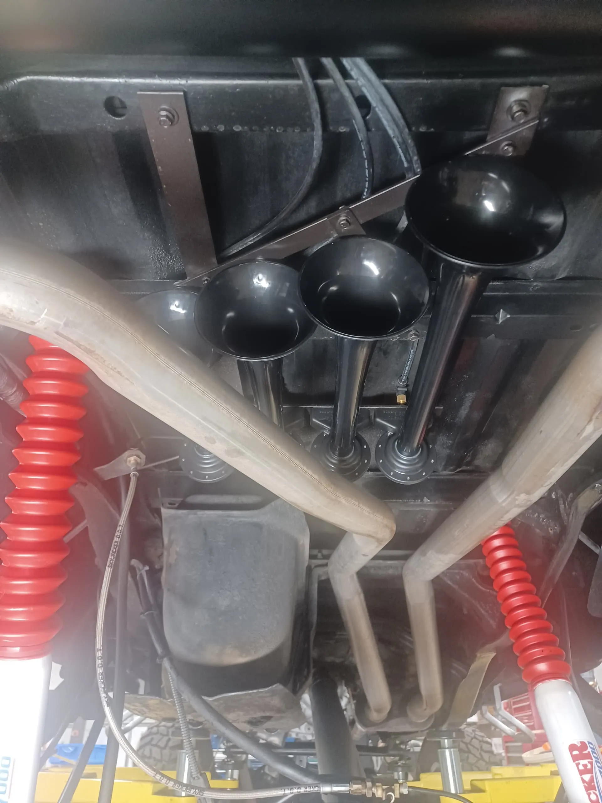 Three black train horns mounted on Brenda's Ford Ranger chassis on shop lift with Skyjacker shocks photo 5